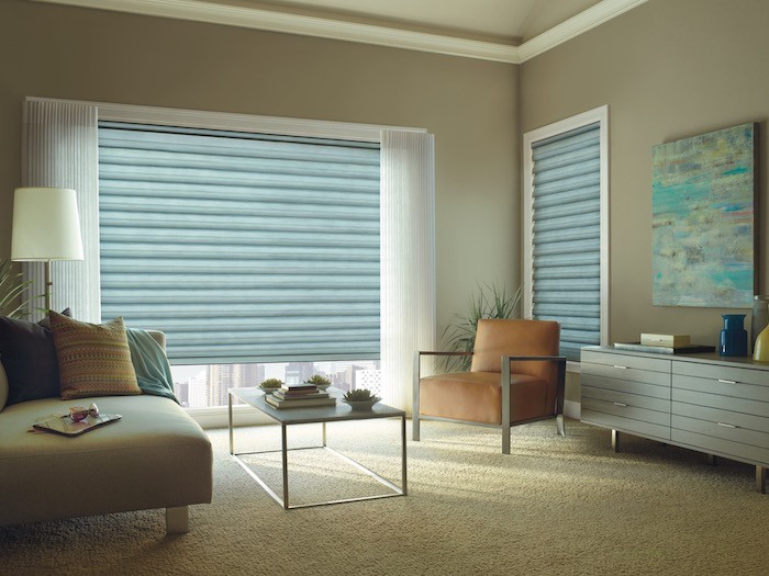 A living room with window coverings and furniture in shades of green and orange.